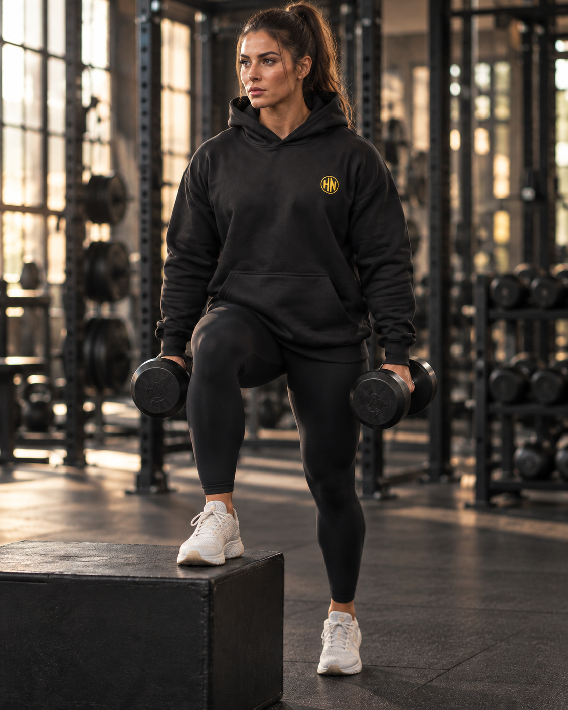 Model exercising with dumbbells in a black Hack Pro Essential oversized hoodie