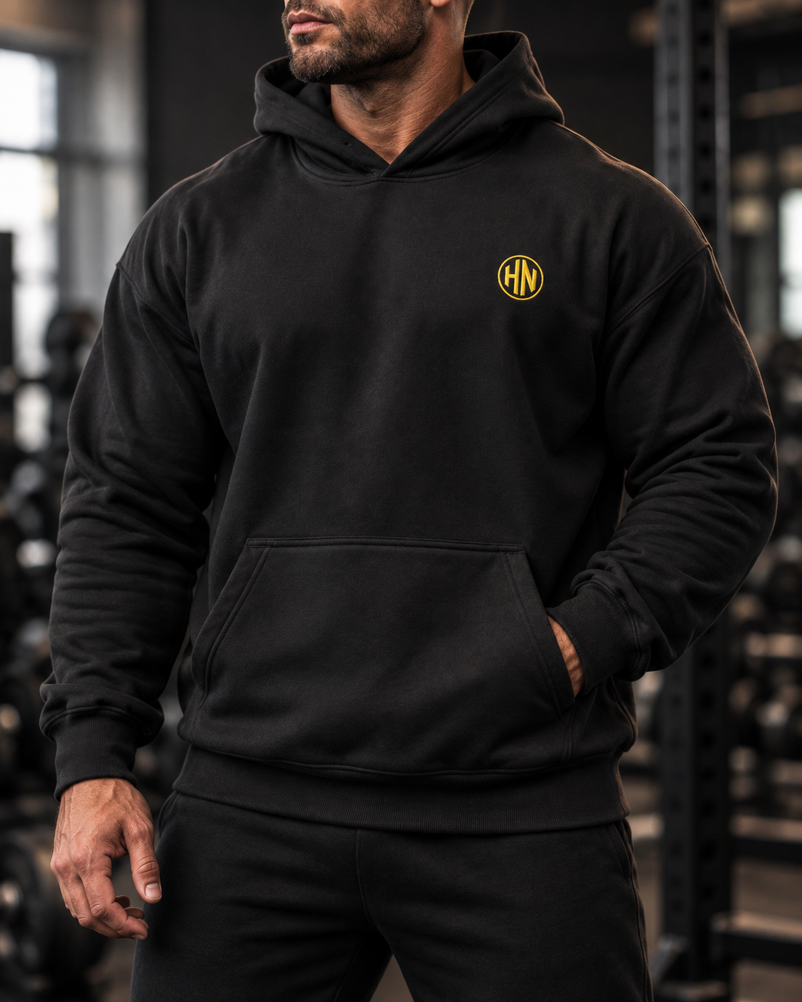 Front detail of the black Hack Pro Essential hoodie with gold logo and pouch pocket