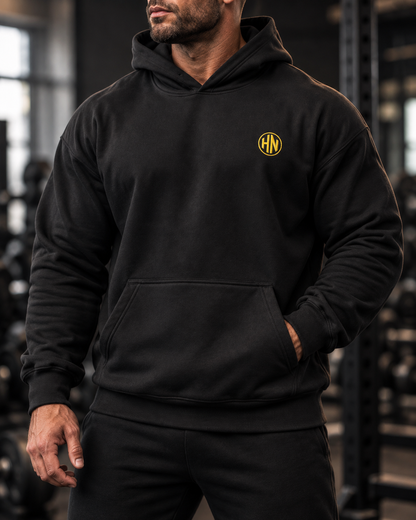 Front detail of the black Hack Pro Essential hoodie with gold logo and pouch pocket