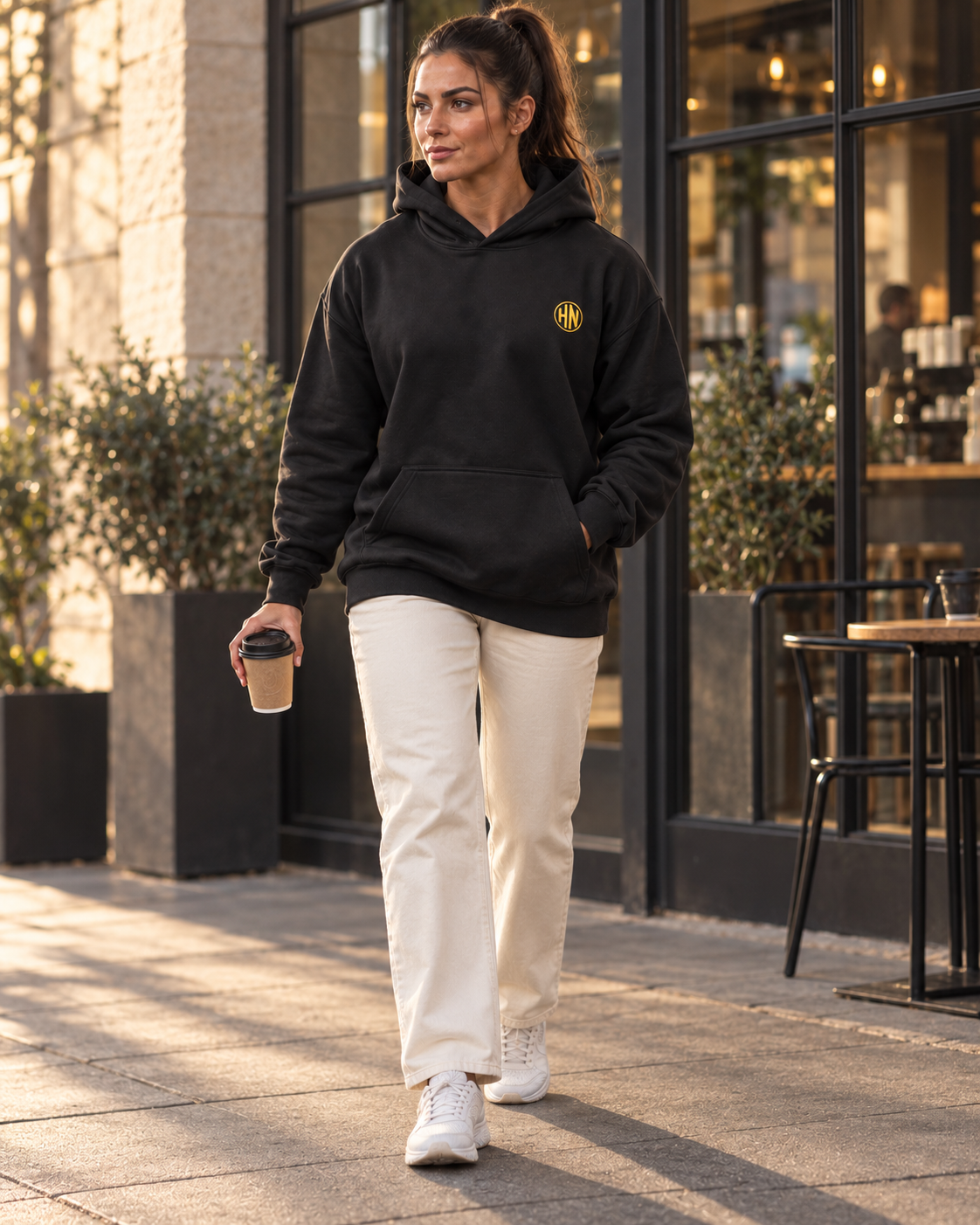Model wearing a black Hack Pro Essential oversized hoodie with light trousers