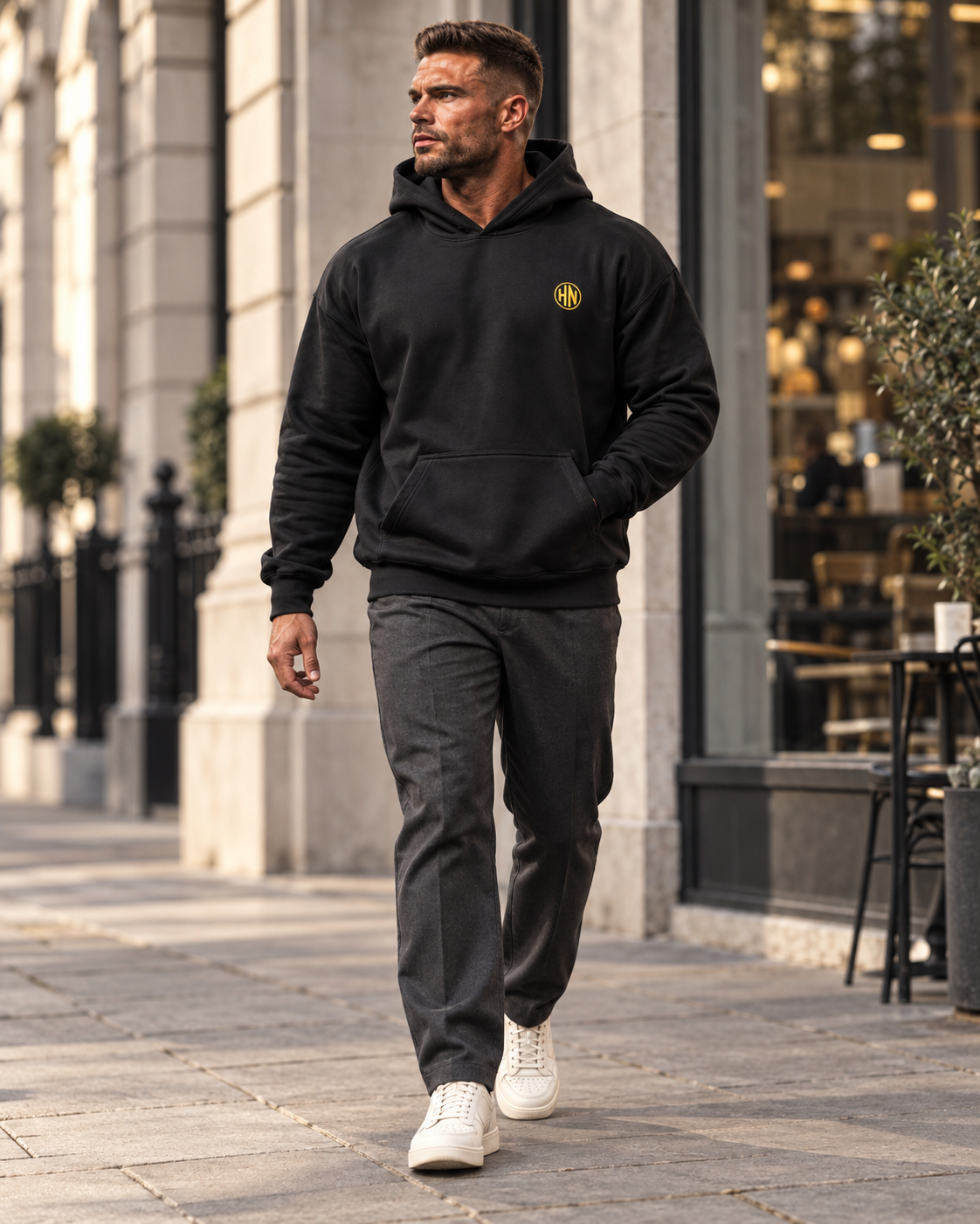 Model walking outdoors in a black Hack Pro Essential oversized hoodie